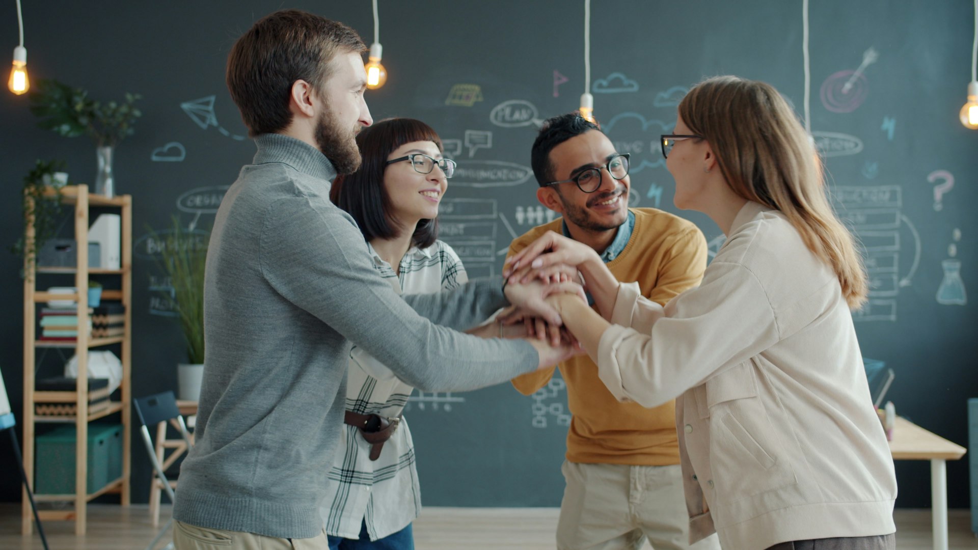 Diverse team celebrates success with a huddle.